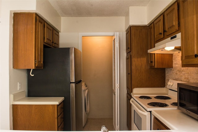1101 Quail Valley Ln Unit 211, Arlington, TX 76011 - kitchen featuring under cabinet range hood, stainless steel appliances, light countertops, brown cabinets, and a textured ceiling