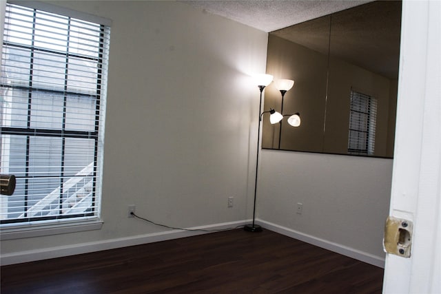 1101 Quail Valley Ln Unit 211, Arlington, TX 76011 - empty room featuring dark wood finished floors, baseboards, and a textured ceiling