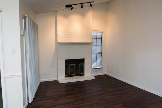 1101 Quail Valley Ln Unit 211, Arlington, TX 76011 - unfurnished living room with track lighting, wood finished floors, baseboards, and a brick fireplace