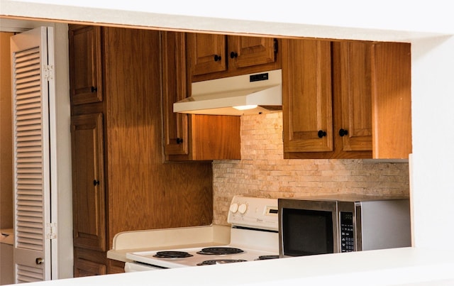 1101 Quail Valley Ln Unit 211, Arlington, TX 76011 - kitchen with electric stove, under cabinet range hood, stainless steel microwave, decorative backsplash, and brown cabinets