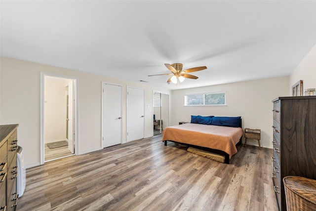 2935 Maydelle Ln, Farmers Branch, TX 75234 - bedroom featuring light wood-type flooring, ceiling fan, ensuite bathroom, two closets, and baseboards