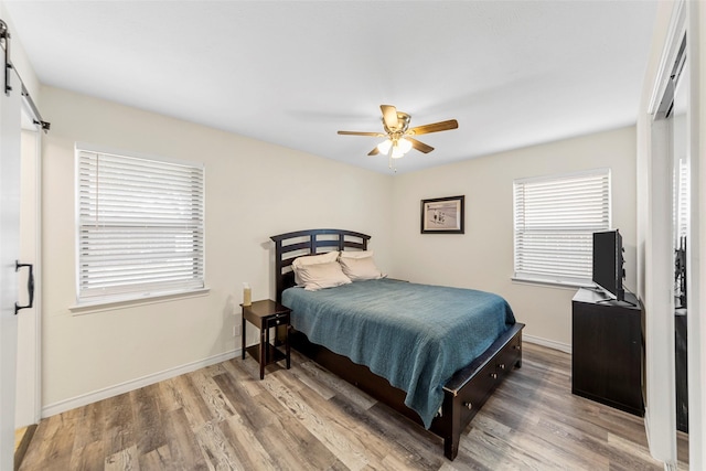2935 Maydelle Ln, Farmers Branch, TX 75234 - bedroom featuring wood finished floors, a barn door, baseboards, and ceiling fan