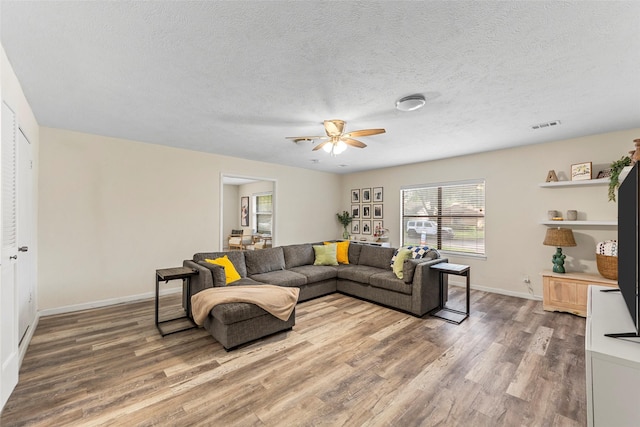 2935 Maydelle Ln, Farmers Branch, TX 75234 - living area featuring light wood finished floors, ceiling fan, baseboards, and a textured ceiling