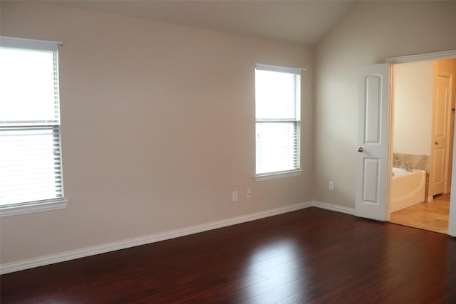 414 Stonecreek Dr, Princeton, TX 75407 - unfurnished bedroom featuring wood finished floors, lofted ceiling, and baseboards