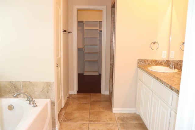 414 Stonecreek Dr, Princeton, TX 75407 - full bath with a spacious closet, a bath, vanity, tile patterned floors, and baseboards