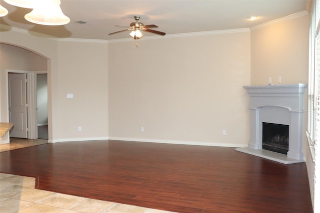 414 Stonecreek Dr, Princeton, TX 75407 - unfurnished living room featuring light wood-type flooring, a ceiling fan, arched walkways, crown molding, and baseboards