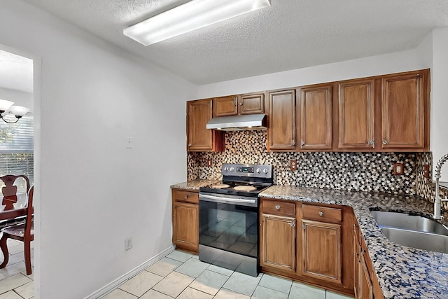kitchen featuring stainless steel electric stove, a sink, under cabinet range hood, tasteful backsplash, and brown cabinetry