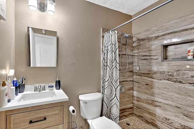 bathroom featuring vanity, a tile shower, and toilet