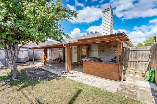 rear view of property with fence, a chimney, a patio, and area for grilling
