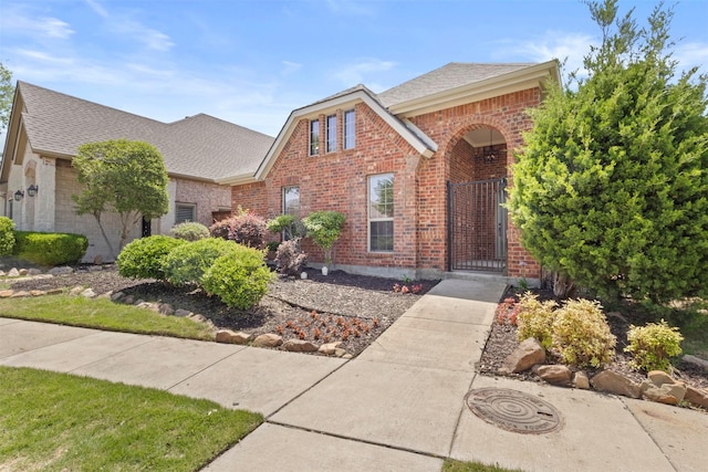 1403 Petersburgh Pl, Allen, TX 75013 - traditional home featuring brick siding, a gate, and a shingled roof
