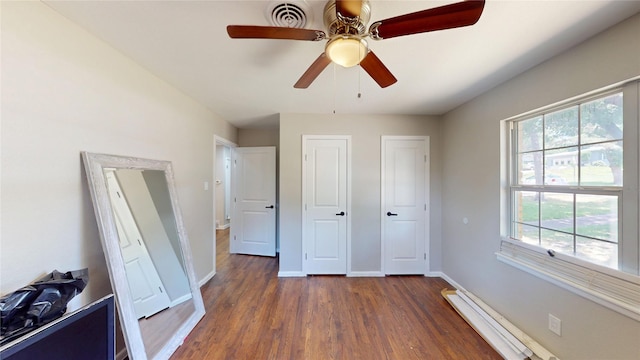 1408 Briarwood Blvd, Arlington, TX 76013 - unfurnished bedroom with dark wood finished floors, baseboards, ceiling fan, and baseboard heating