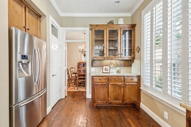 8917 Cypress Creek Rd, Lantana, TX 76226 - kitchen with stainless steel fridge, brown cabinets, dark wood finished floors, ornamental molding, and glass insert cabinets