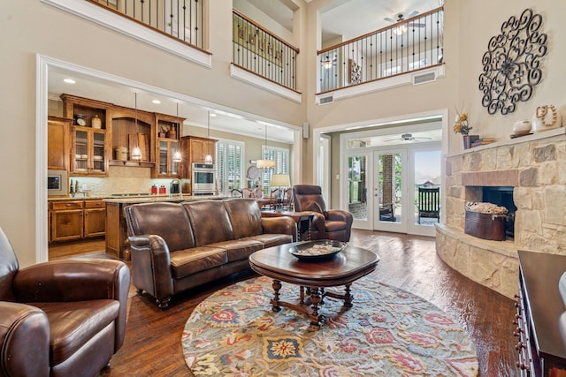 8917 Cypress Creek Rd, Lantana, TX 76226 - living area with dark wood-style floors, plenty of natural light, a stone fireplace, and a towering ceiling