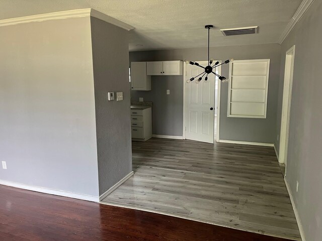2836 Modree Ave, Dallas, TX 75216 - unfurnished dining area with a chandelier, baseboards, crown molding, wood finished floors, and a textured ceiling