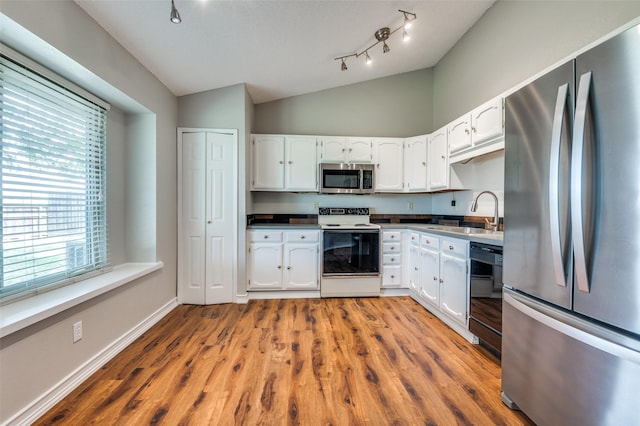 2005 Parkside Dr, Denton, TX 76201 - kitchen with stainless steel appliances, a sink, lofted ceiling, plenty of natural light, and white cabinetry