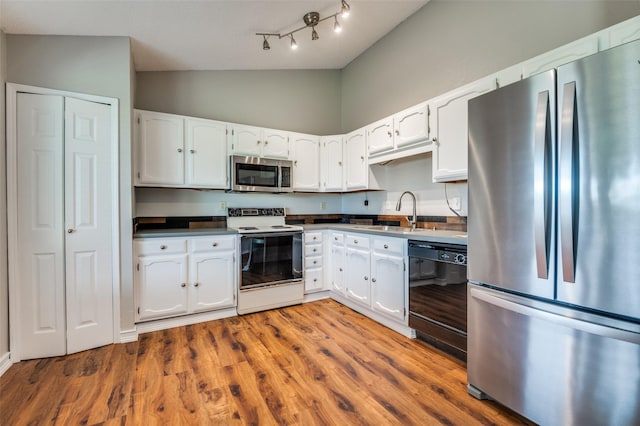 2005 Parkside Dr, Denton, TX 76201 - kitchen featuring appliances with stainless steel finishes, a sink, white cabinetry, and high vaulted ceiling