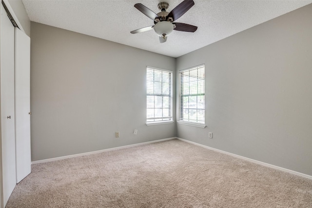 2005 Parkside Dr, Denton, TX 76201 - carpeted spare room featuring a textured ceiling, a ceiling fan, and baseboards