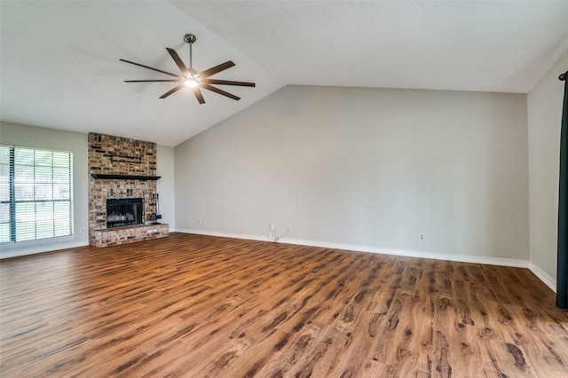 2005 Parkside Dr, Denton, TX 76201 - unfurnished living room featuring a ceiling fan, wood finished floors, a brick fireplace, lofted ceiling, and baseboards