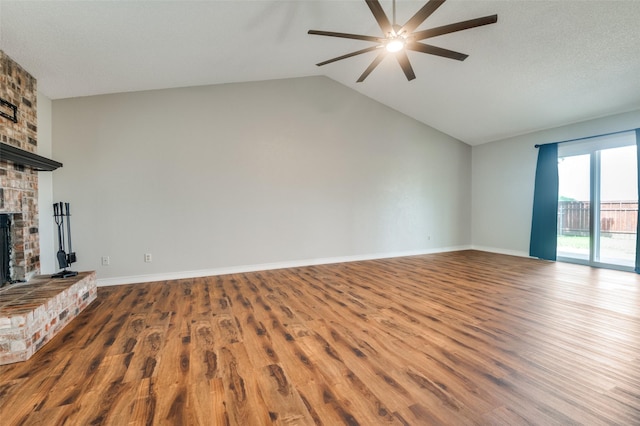 2005 Parkside Dr, Denton, TX 76201 - unfurnished living room featuring a brick fireplace, ceiling fan, wood finished floors, lofted ceiling, and baseboards