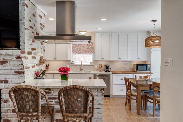 7219 Haverford Rd, Dallas, TX 75214 - kitchen with island range hood, appliances with stainless steel finishes, a sink, and white cabinets
