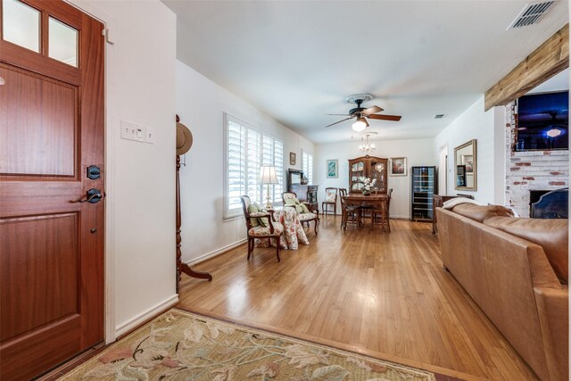 7219 Haverford Rd, Dallas, TX 75214 - entrance foyer featuring a ceiling fan, light wood-type flooring, a fireplace, and baseboards