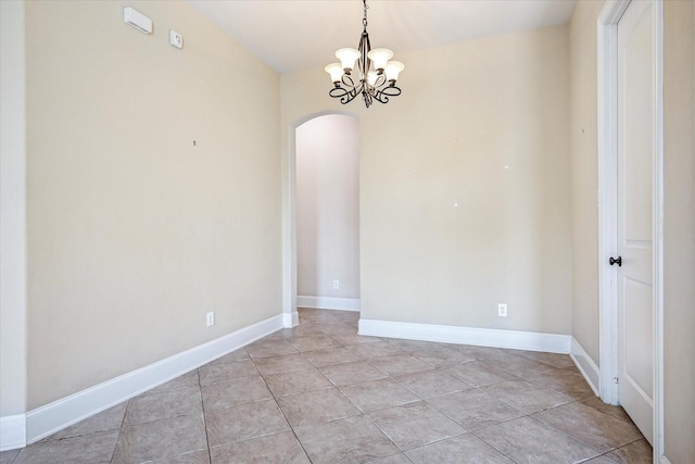 unfurnished room with arched walkways, a chandelier, and baseboards