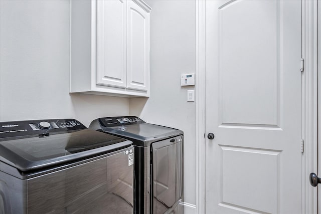 clothes washing area featuring independent washer and dryer and cabinet space