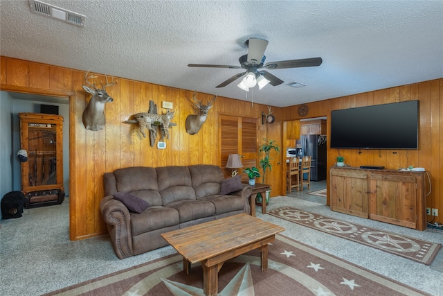 2405 Poolville Cut Off Rd, Poolville, TX 76487 - carpeted living room featuring ceiling fan, wood walls, and a textured ceiling
