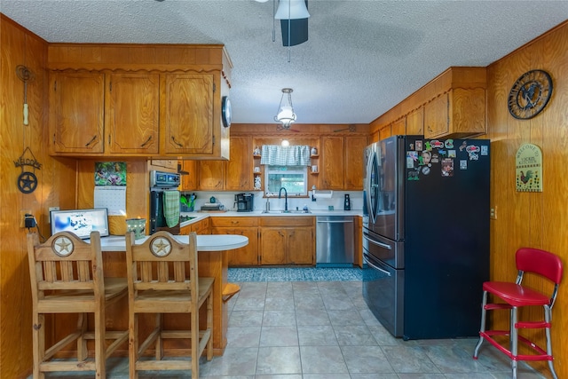 2405 Poolville Cut Off Rd, Poolville, TX 76487 - kitchen featuring stainless steel appliances, brown cabinetry, light countertops, a sink, and a textured ceiling
