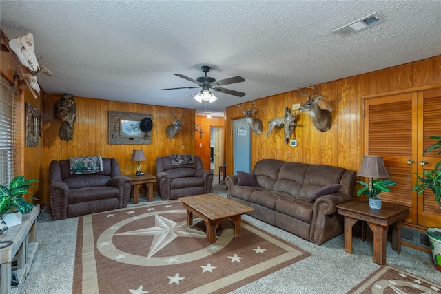 2405 Poolville Cut Off Rd, Poolville, TX 76487 - living area featuring carpet floors, a ceiling fan, wooden walls, and a textured ceiling