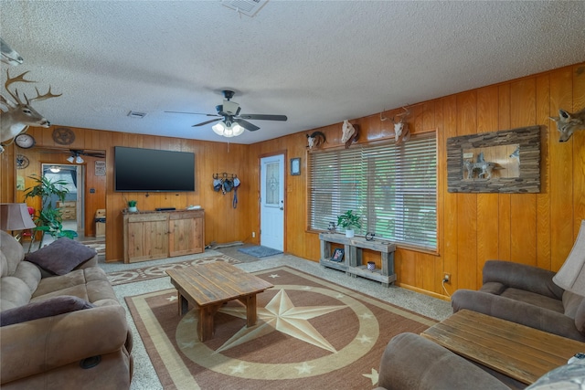 2405 Poolville Cut Off Rd, Poolville, TX 76487 - carpeted living room with ceiling fan, wooden walls, and a textured ceiling