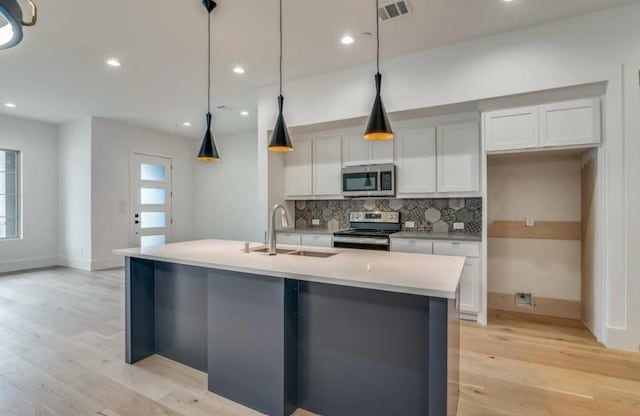 822 Eaglescliffe Lndg, Wylie, TX 75098 - kitchen with stainless steel appliances, a sink, backsplash, light wood finished floors, and an island with sink