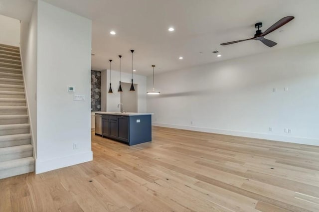 822 Eaglescliffe Lndg, Wylie, TX 75098 - unfurnished living room featuring a sink, stairs, baseboards, light wood-type flooring, and ceiling fan