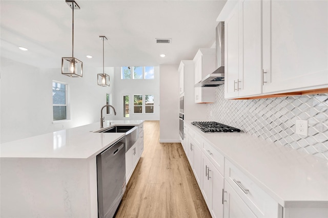 220 E Park St, Little Elm, TX 75068 - kitchen featuring stainless steel appliances, wall chimney range hood, a sink, light wood-style flooring, and a kitchen island with sink