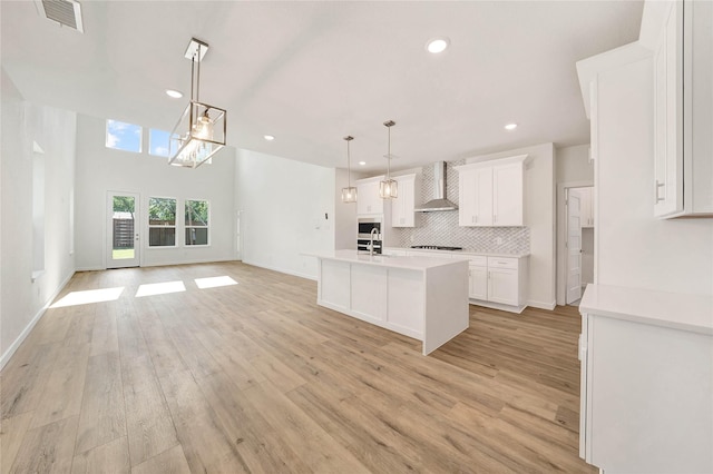 220 E Park St, Little Elm, TX 75068 - kitchen with wall chimney range hood, recessed lighting, tasteful backsplash, light wood finished floors, and white cabinets