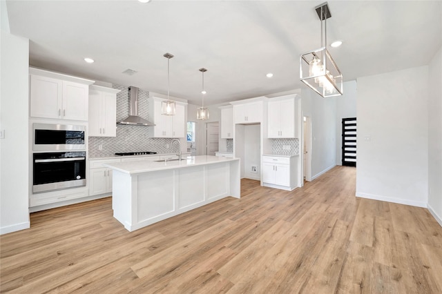 220 E Park St, Little Elm, TX 75068 - kitchen featuring stainless steel appliances, wall chimney range hood, a sink, tasteful backsplash, and white cabinetry