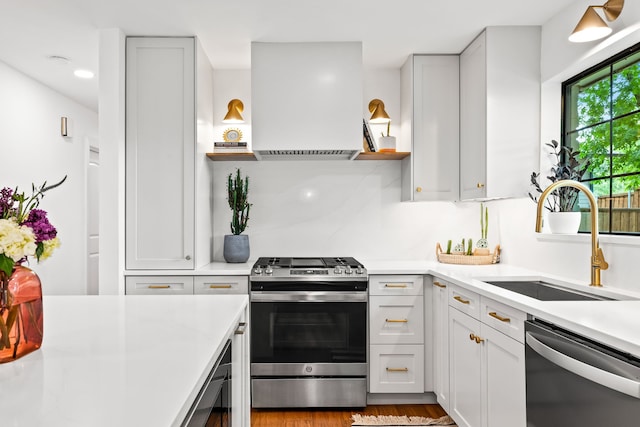 9115 Longmont Dr, Dallas, TX 75238 - kitchen featuring stainless steel appliances, a sink, extractor fan, open shelves, and light countertops