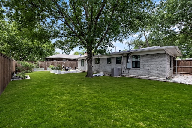 9115 Longmont Dr, Dallas, TX 75238 - back of house featuring central air condition unit, a patio, brick siding, and a chimney