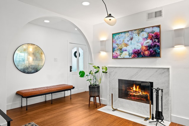 9115 Longmont Dr, Dallas, TX 75238 - living area with a fireplace, wood finished floors, arched walkways, and recessed lighting
