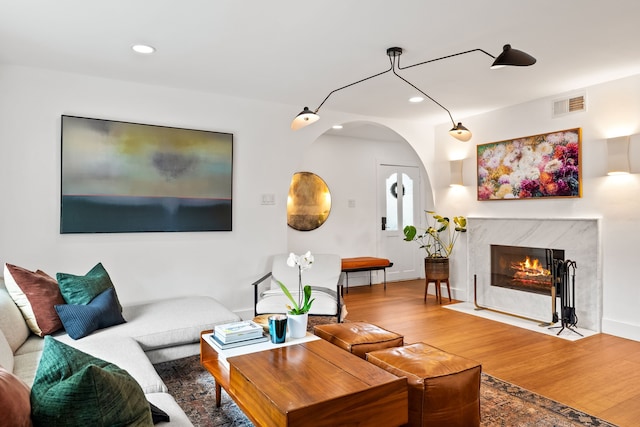 9115 Longmont Dr, Dallas, TX 75238 - living area with wood finished floors, recessed lighting, a fireplace, arched walkways, and baseboards