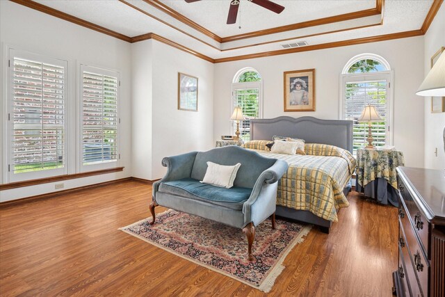 3517 Louis Dr, Plano, TX 75023 - bedroom with multiple windows, wood finished floors, a tray ceiling, ornamental molding, and a ceiling fan