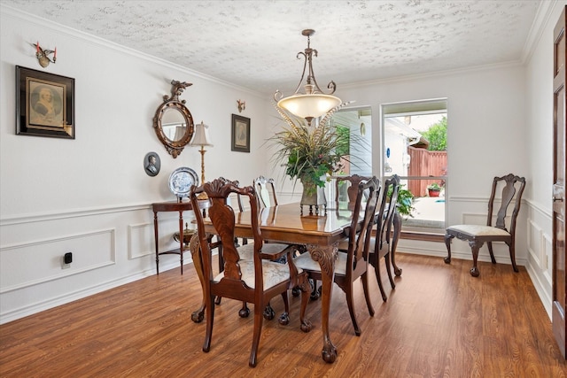 3517 Louis Dr, Plano, TX 75023 - dining space with wood finished floors, a decorative wall, a textured ceiling, and wainscoting