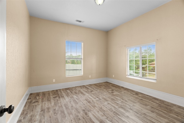 2721 Ave G, Fort Worth, TX 76105 - unfurnished room featuring wood finished floors, plenty of natural light, and baseboards