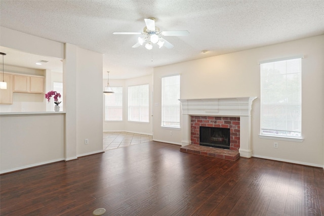 7104 Chandler Dr, Plano, TX 75024 - unfurnished living room with a ceiling fan, wood finished floors, plenty of natural light, a textured ceiling, and baseboards