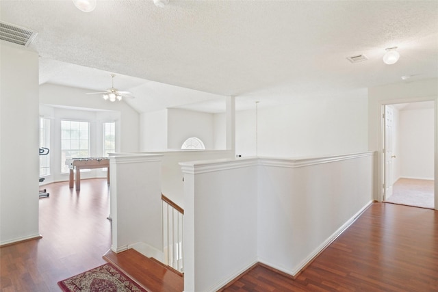 7104 Chandler Dr, Plano, TX 75024 - hall featuring dark wood-type flooring, a textured ceiling, an upstairs landing, lofted ceiling, and baseboards