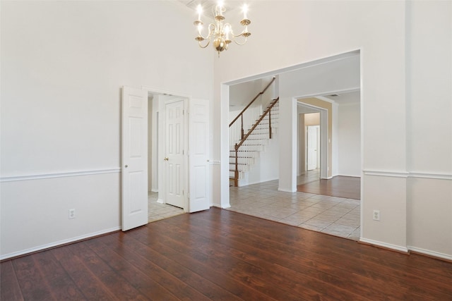 7104 Chandler Dr, Plano, TX 75024 - empty room featuring a chandelier, hardwood / wood-style floors, stairway, baseboards, and a high ceiling