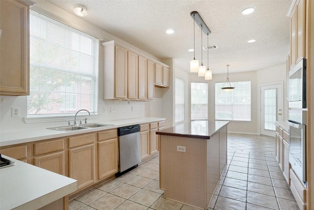 7104 Chandler Dr, Plano, TX 75024 - kitchen featuring stainless steel appliances, light brown cabinets, a sink, a textured ceiling, and a kitchen island