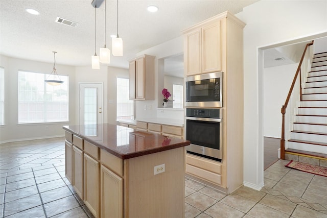 7104 Chandler Dr, Plano, TX 75024 - kitchen featuring stainless steel appliances, a center island, light brown cabinetry, light tile patterned floors, and recessed lighting