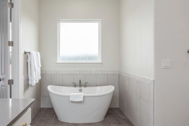 3316 Acorn Hill Trl, Weatherford, TX 76087 - full bathroom featuring tile walls, a freestanding bath, tile patterned flooring, wainscoting, and vanity
