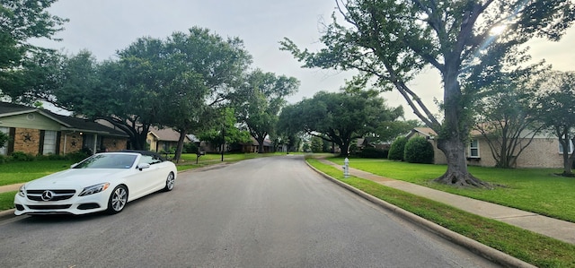 605 Sevilla Dr, Garland, TX 75043 - view of asphalt road featuring curbs, sidewalks, and a residential view